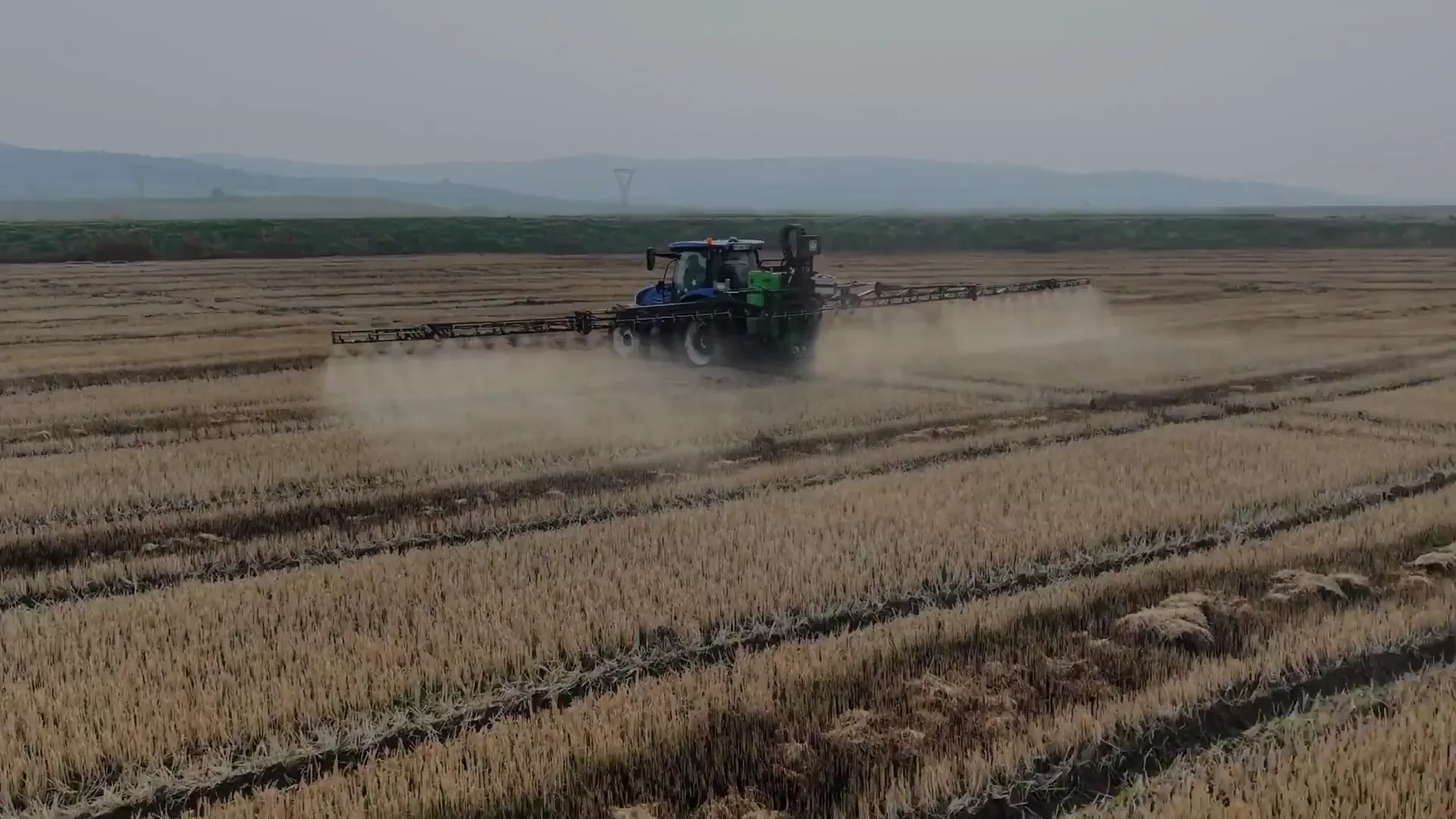 Crop sprayer operating across a harvested field